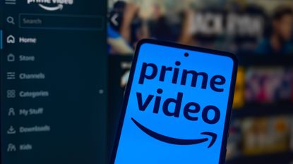 Phone displaying the Amazon Prime Video logo in front of the Prime Video interface on a monitor