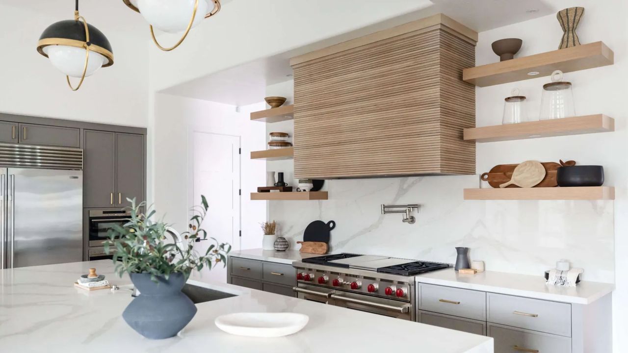 A kitchen with marble counters and wooden open shelving