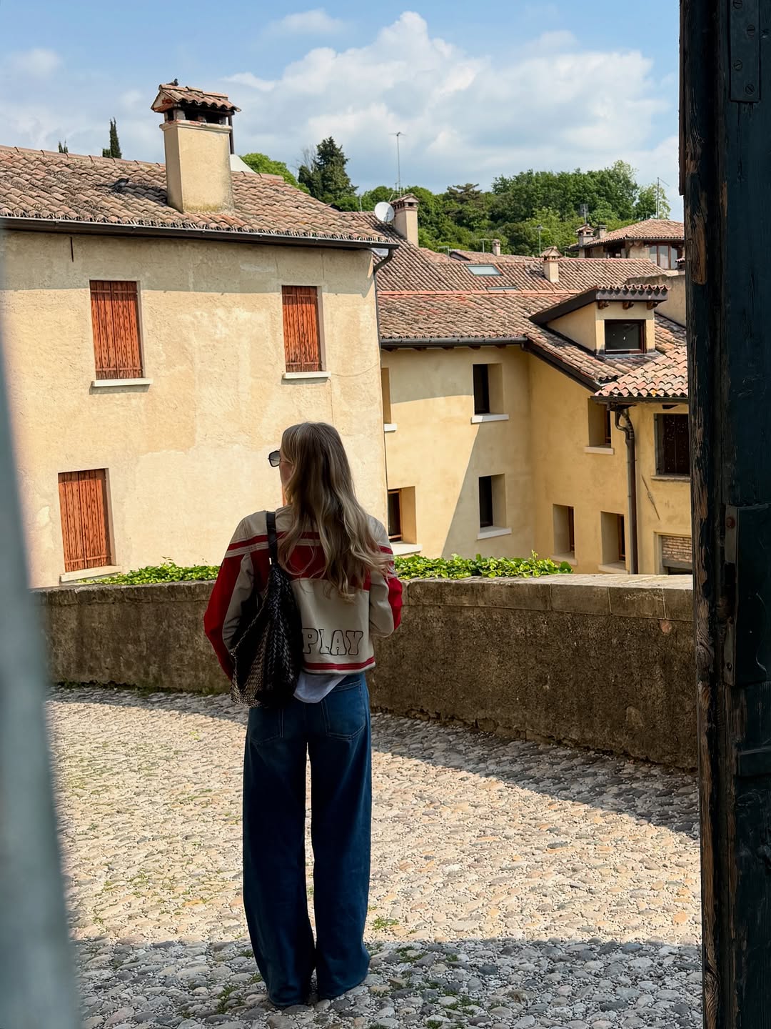 Woman wearing long, baggy jeans fall denim trend 2025.