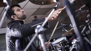 Kaz Rodriguez plays drums wearing in-ear monitors
