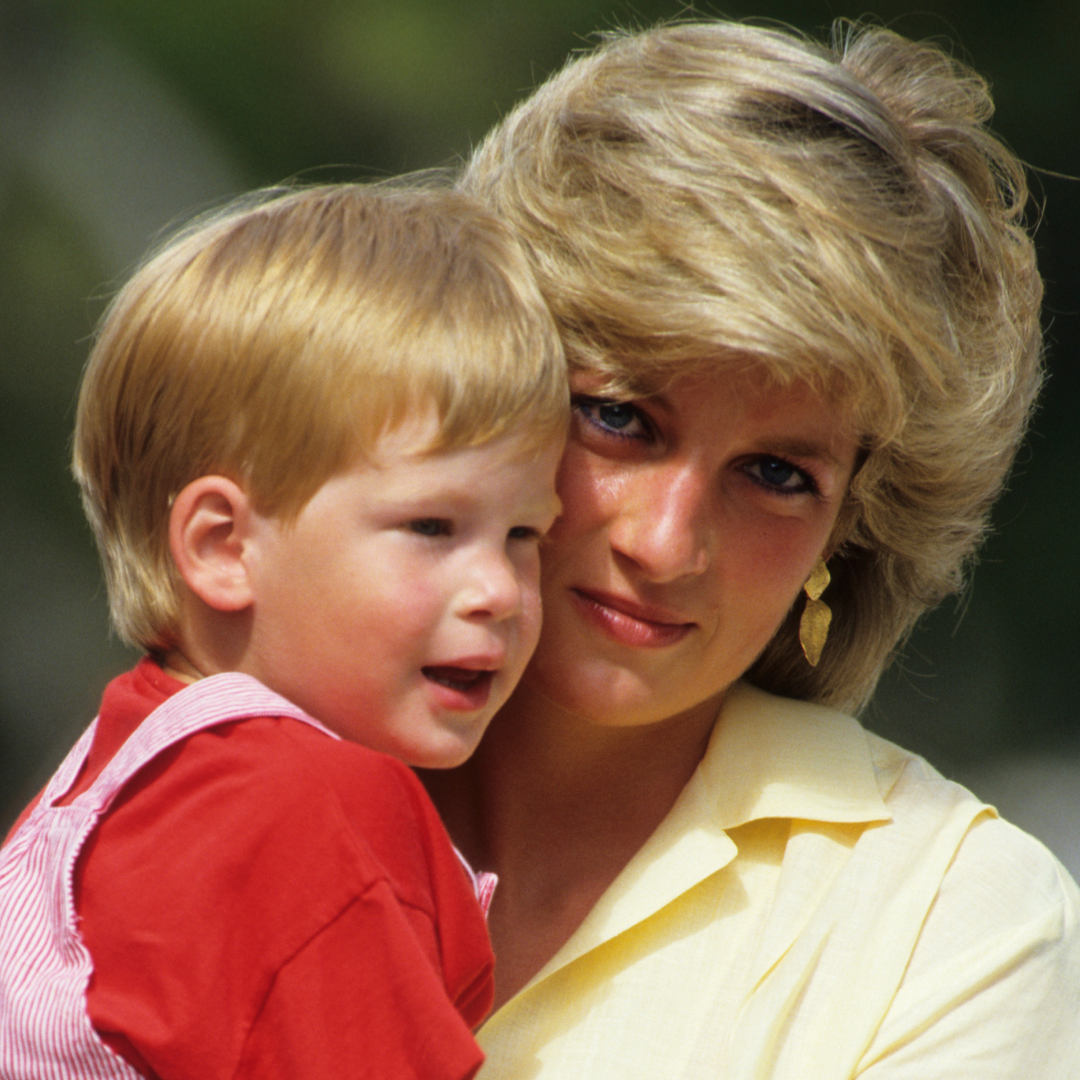 Princess Diana holding a young Prince Harry and pressing her face against him