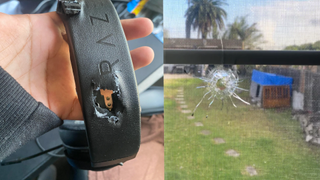 A Razer headset next to a window with a bullet hole