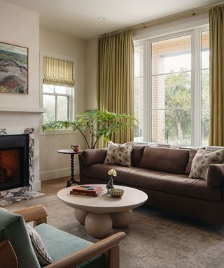 neutral living room with floor to ceiling yellow drapes and colorful furniture