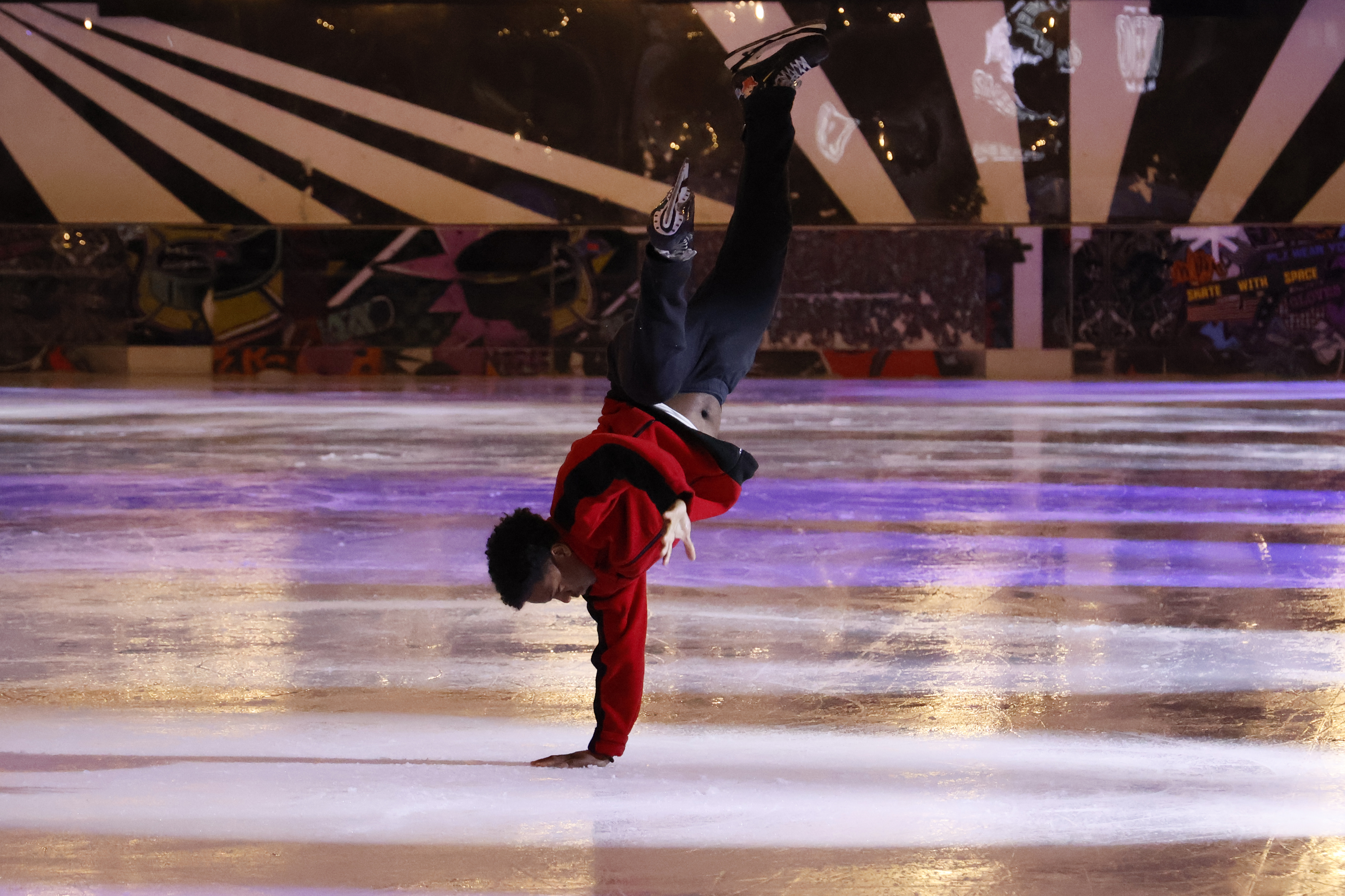 An ice skater performing at an ice rink