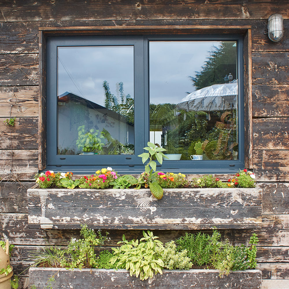 wooden window boxes filled with flowers, plants and herbs