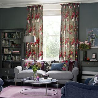 living room with window having floral printed curtains