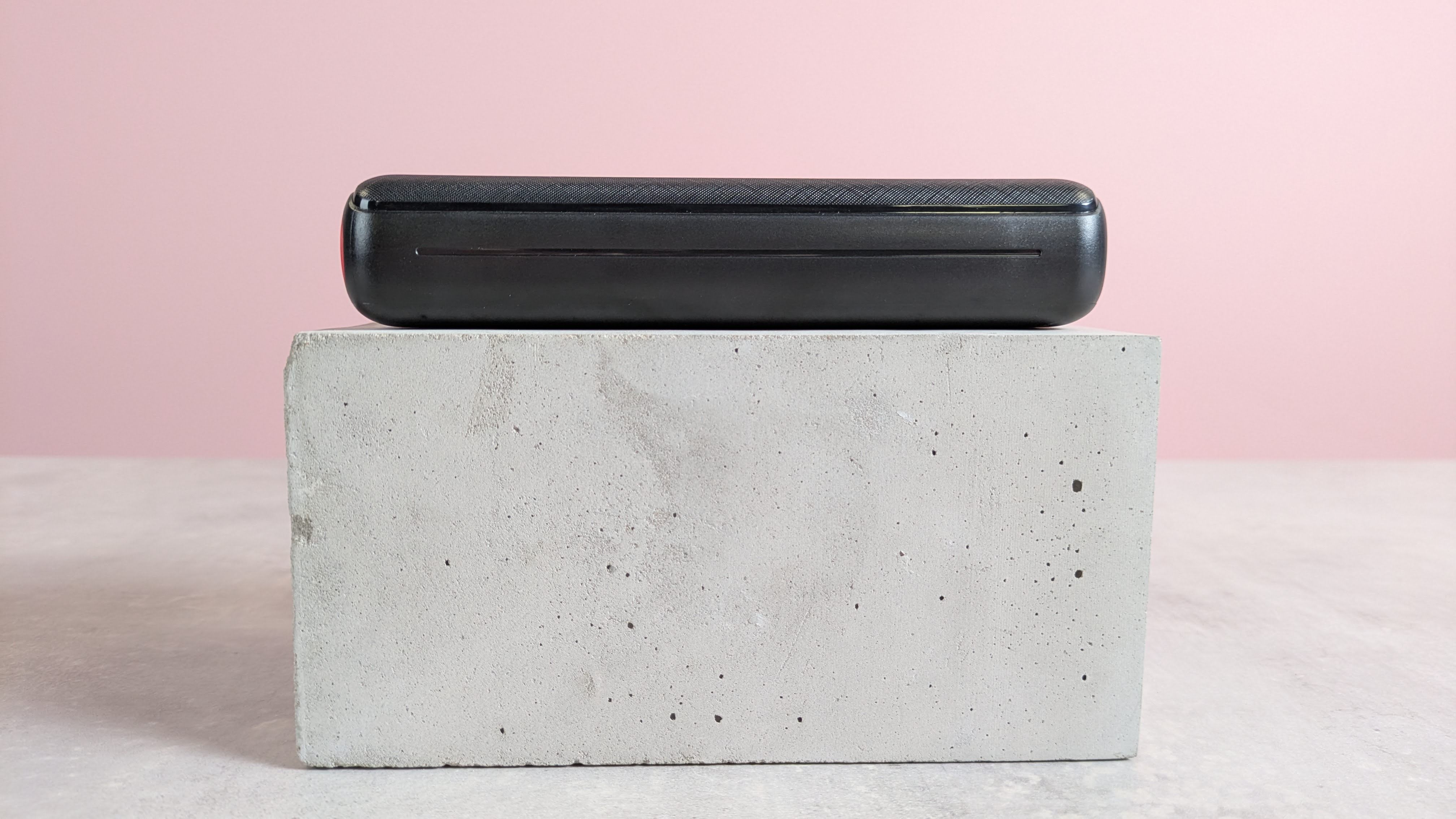 Side view of Jiga 27000mah electric bank with pink background on base