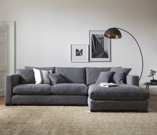 white living room with carpet flooring and grey sofa set