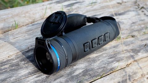 Pulsar Telos XQ35 monocular resting on a log outside