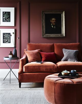 Dark orange velvet sofa in a living room with dark red walls