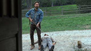 James (Scott Speedman) holds a gun next to a body in Teacup