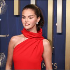 a woman in a red dress wearing a high ponytail
