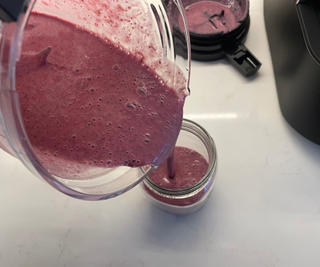 Pouring a smooth berry smoothie from the Tiger 45 Degree Diagonal Blade blender in my test kitchen