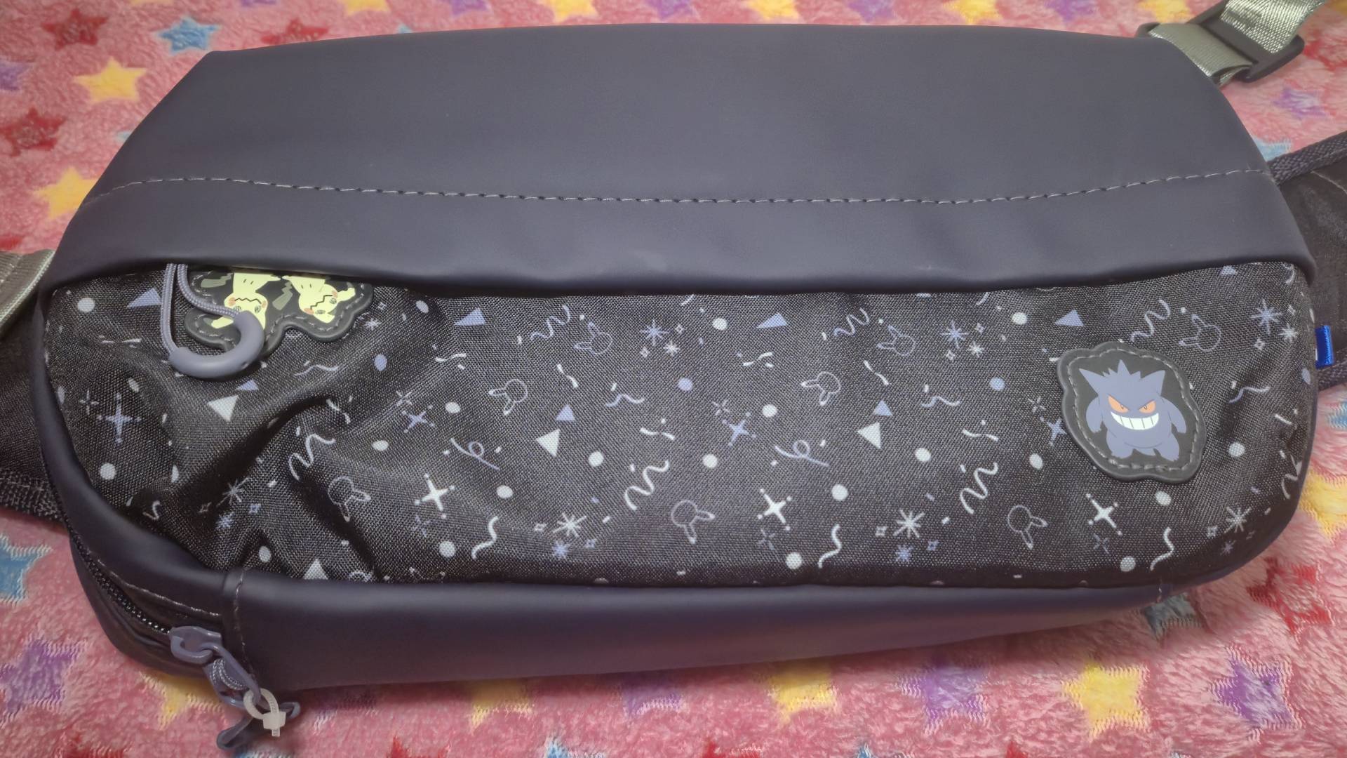 Photo of the Hori Gengar and Mimikyu Adventure Pack sitting on a pink star patterned blanket.