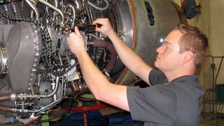 A GE Aviation engineer performing jet engine maintenance with the help of Google Glass