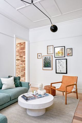 white living room with brown chair and round white coffee table