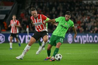 PSV Eindhoven's Dutch forward #09 Luuk De Jong (L) and Sporting Lisbon's Portuguese defender #25 Goncalo Inacio (R) fight for the ball during the UEFA Champions League 1st round day 2 football match between PSV Eindhoven (NED) and Sporting Lisbon (POR) at the The Philips Stadion, in Eindhoven, on October 1, 2024.