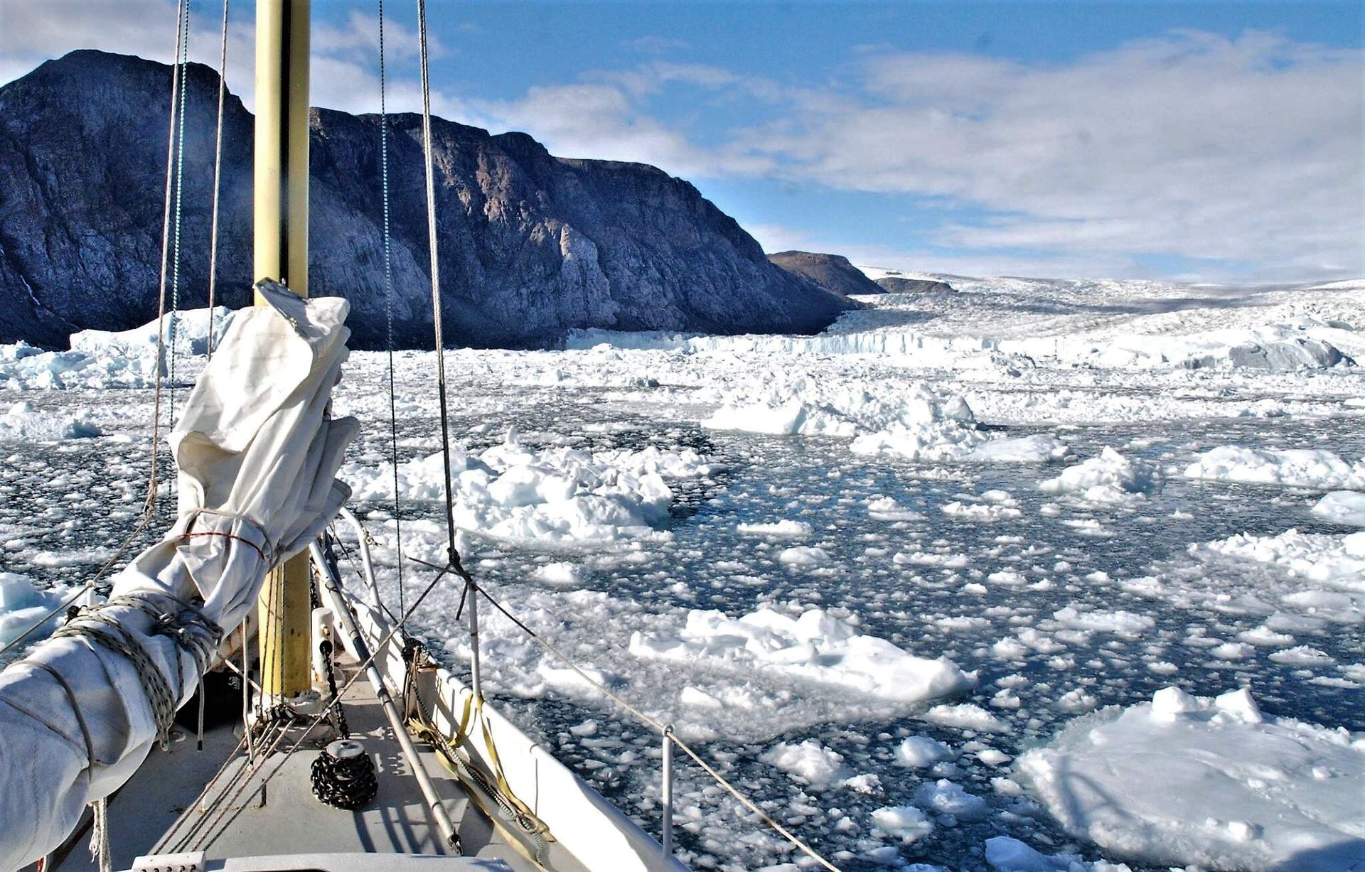 A ship floats between ice in the Arctic.