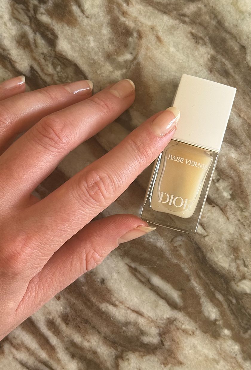 Eleanor's nails and the Dior Base Vernis nail polish bottle on a marble background