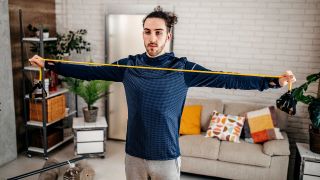 Man performs chest exercise with resistance band