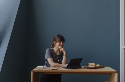 Woman in her 30s having a lunch break and using tablet, looking at something funny on the internet