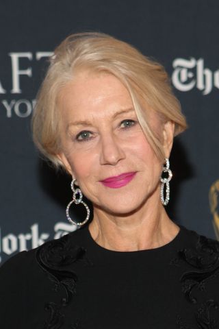 Image of Helen Mirren with short blonde hair, wearing a pink lipstick, a black dress and diamond circular earrings