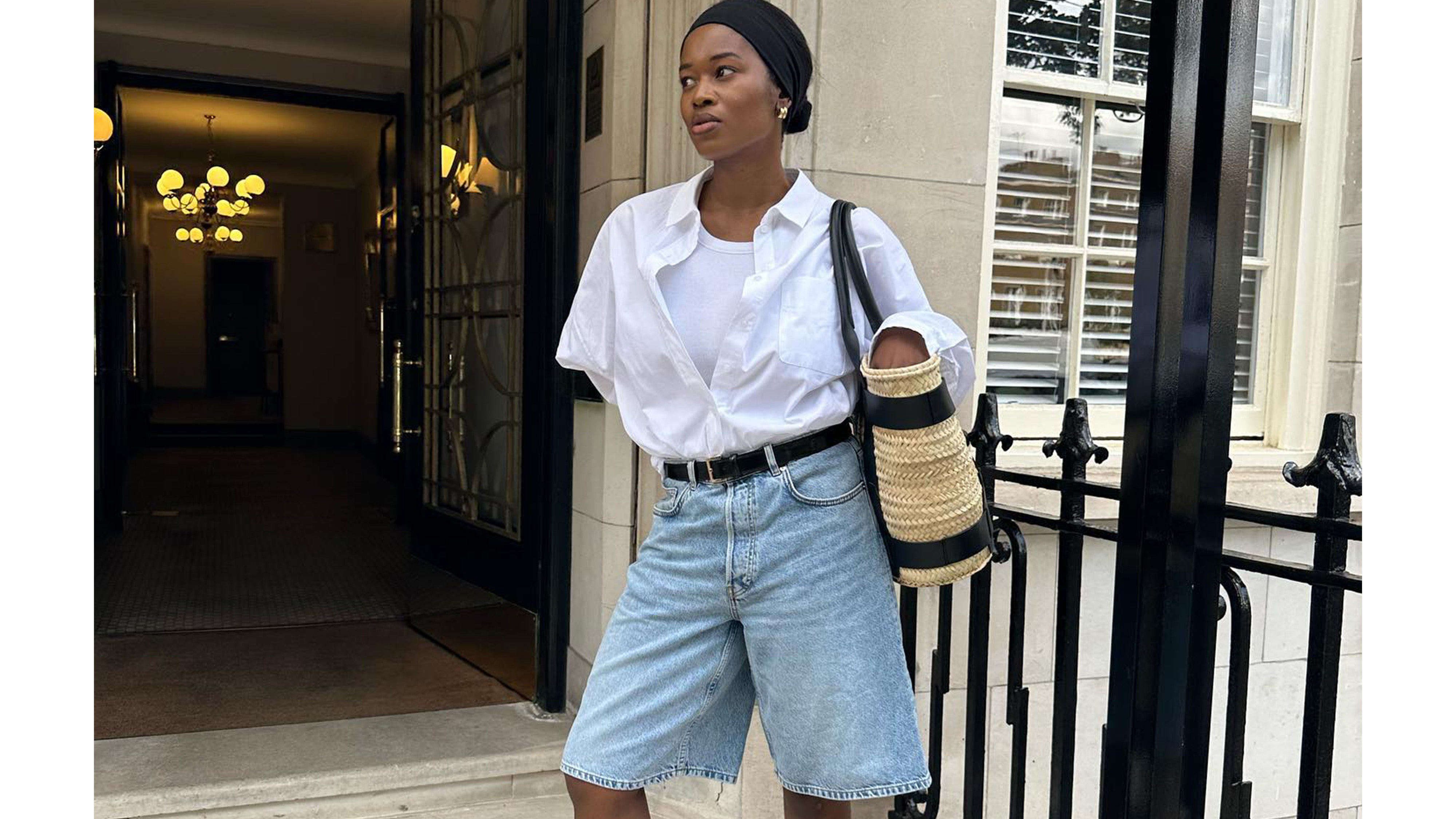 An influencer wearing relaxed denim shorts and a white shirt.