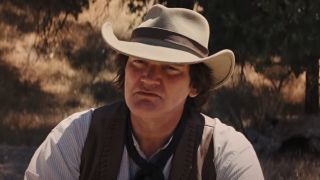 Quentin Tarantino listening intently while dressed in western gear in Django Unchained.