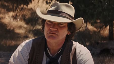 Quentin Tarantino listening intently while dressed in western gear in Django Unchained.