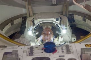 NASA astronaut Andrew Feustel, STS-134 mission specialist, attired in an Extravehicular Mobility Unit (EMU) spacesuit, enters the Quest airlock of the International Space Station as the mission's third spacewalk draws to a close on May 25, 2011.