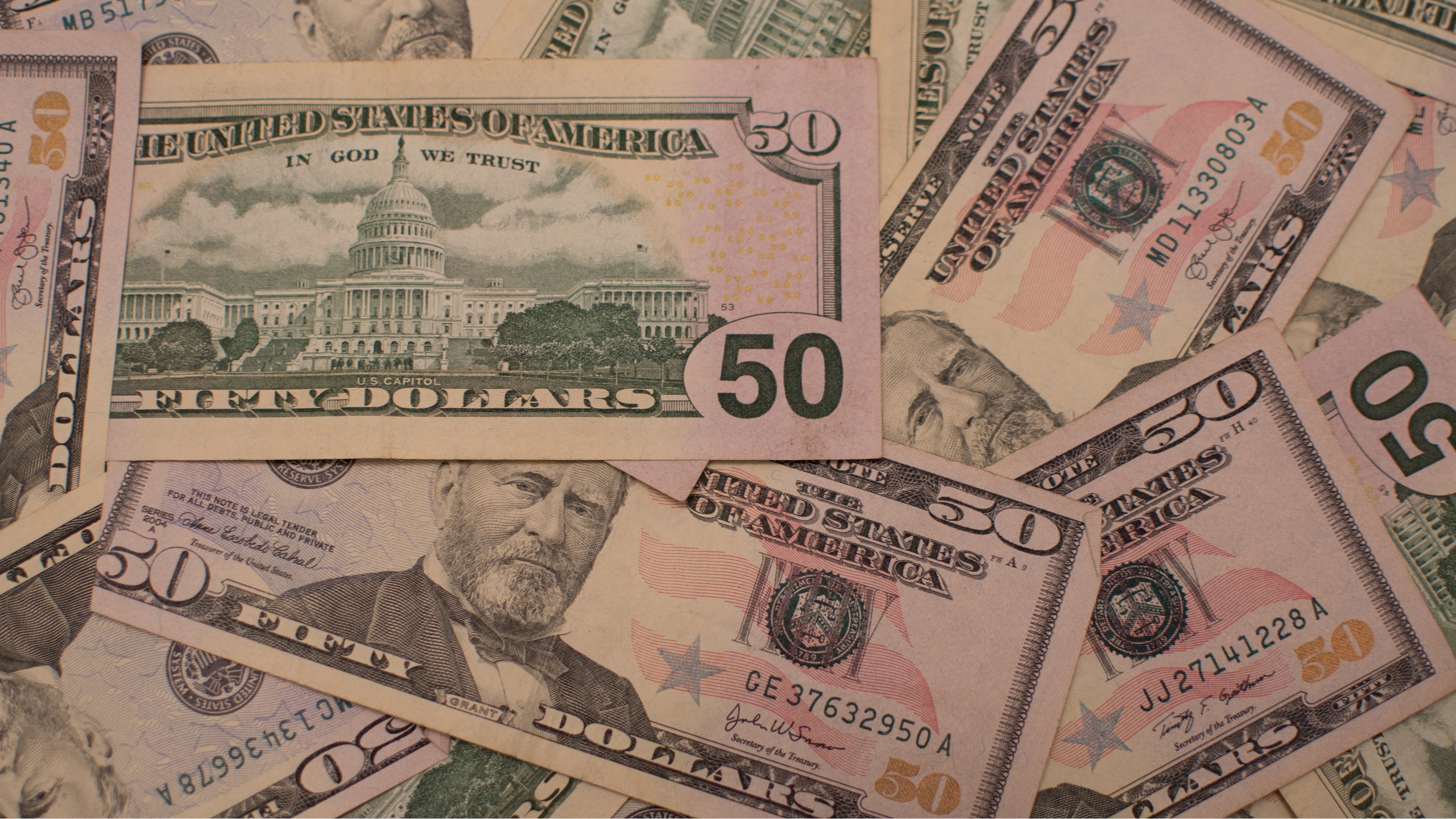 A scattered pile of fifty-dollar bills.