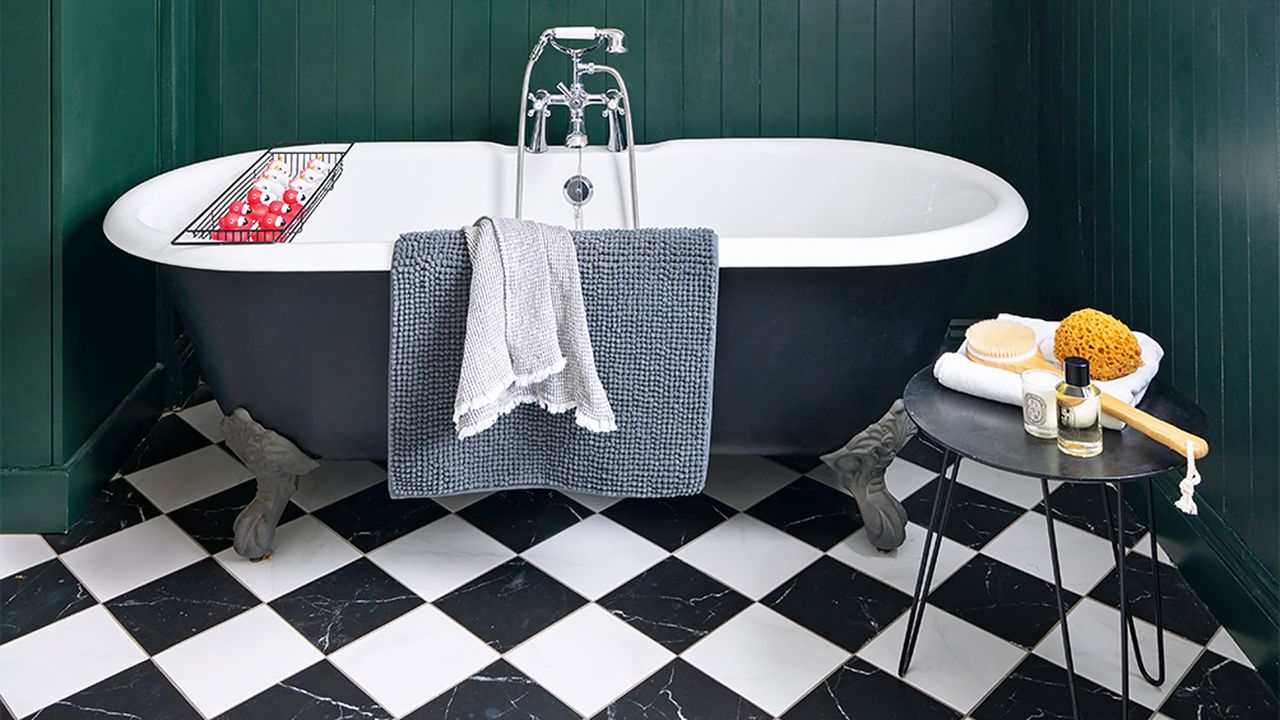 bathroom with black bath and black and white tiled floor