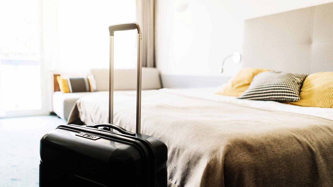 suitcase next to a hotel bed