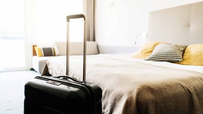 suitcase next to a hotel bed