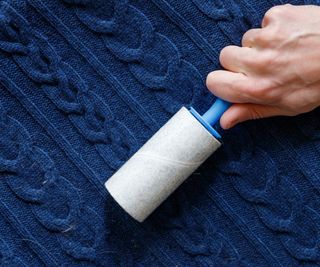 A lint roller on a blue knit sweater