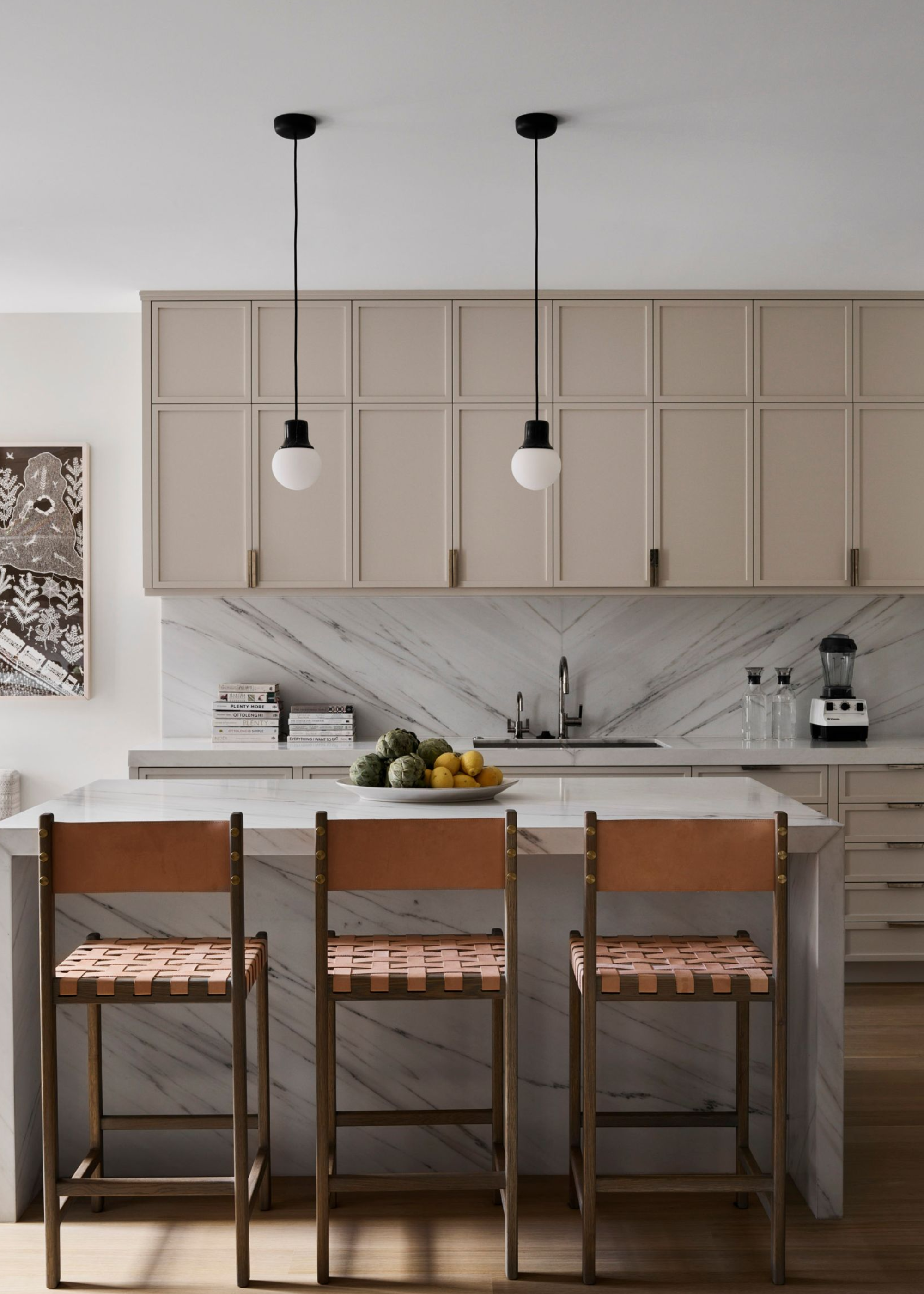 Marble kitchen island, beige kitchen cabinets, brown chairs