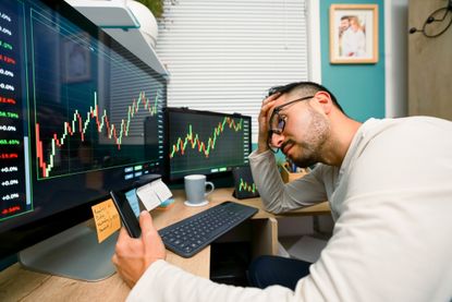 A stressed investor checks his investments.