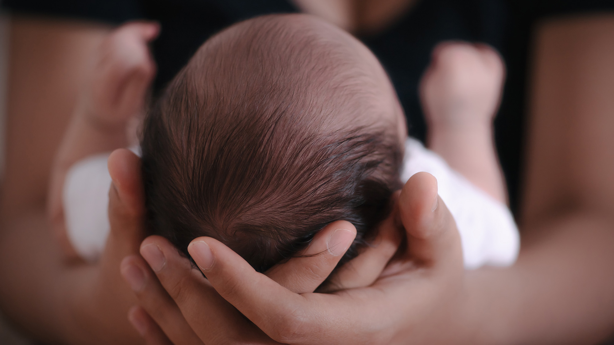 A woman holds her infant baby.