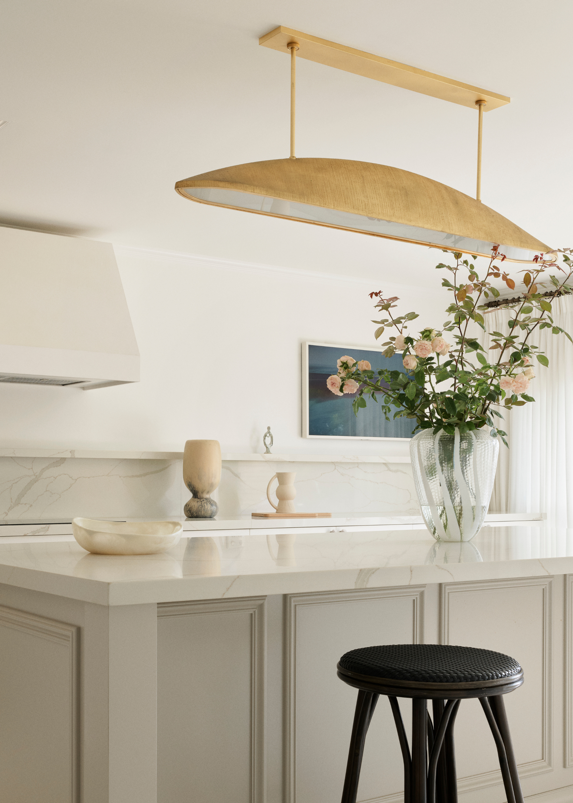 luxury, cashmere greige kitchen with a gold light above the island