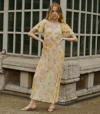 a model wears a yellow floral midi dress