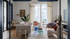 Beautiful open plan living room through an arched door way with floor to ceiling windows and contemporary furniture