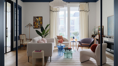 Beautiful open plan living room through an arched door way with floor to ceiling windows and contemporary furniture