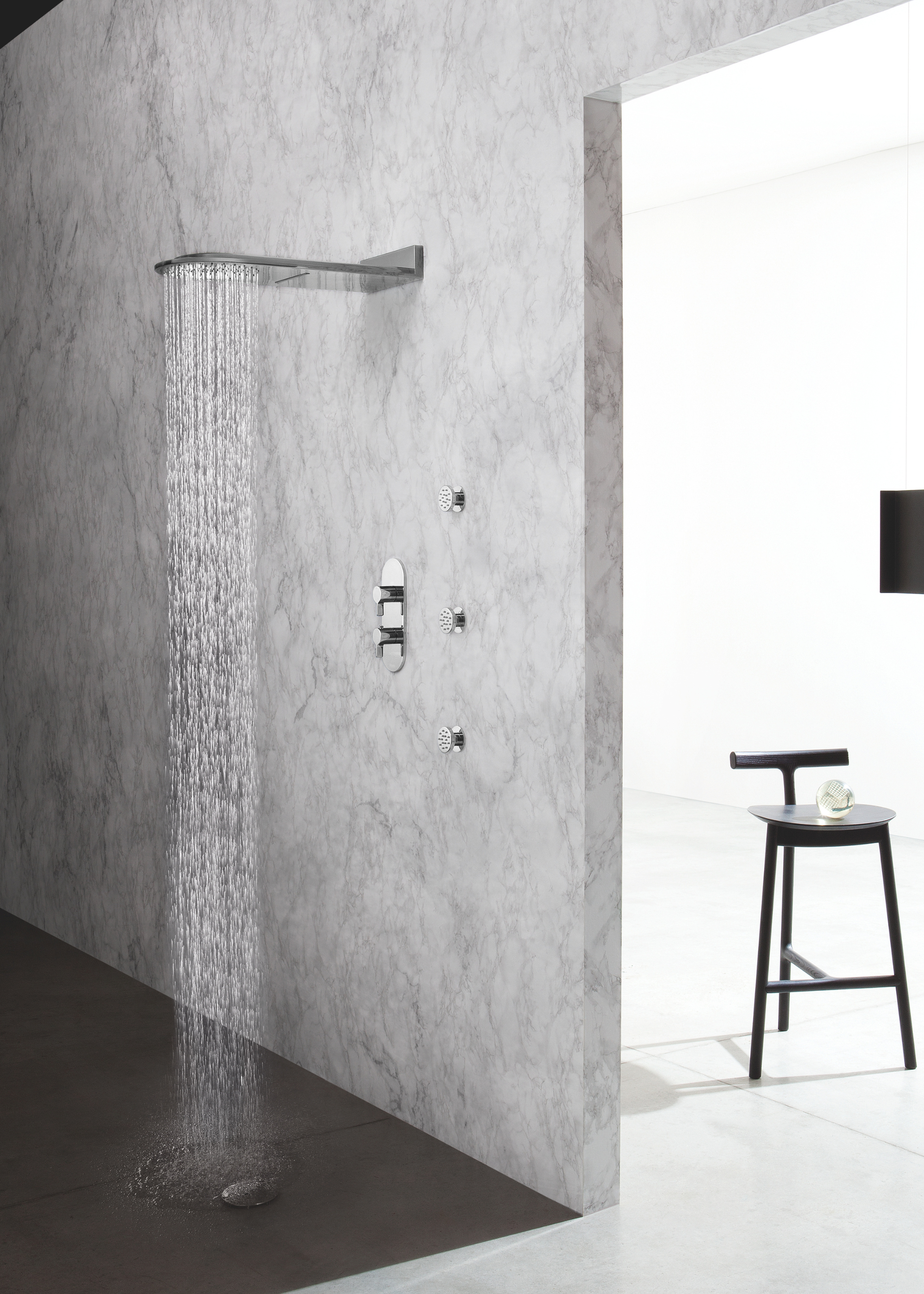 innovative shower system on a marble wall and a wall between another room with a stool inside