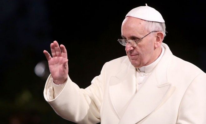 Pope Francis waves as he presides over the Way of The Cross procession at the Colosseum on Good Friday March 29 in Rome.