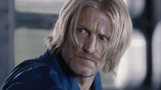 Woody Harrelson's Haymitch looking intensely at Katniss for trying to stab him with a knife in The Hunger Games 