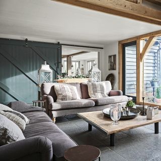 Rustic barn-style living room with grey painted sliding screen and grey sofa