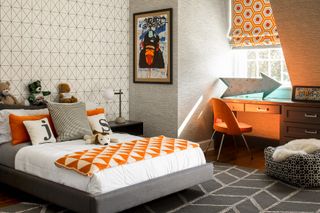 orange and gray boy's bedroom with with graphic wallpaper, rug, blind and blanket, gray rug and wallpaper, grey bed