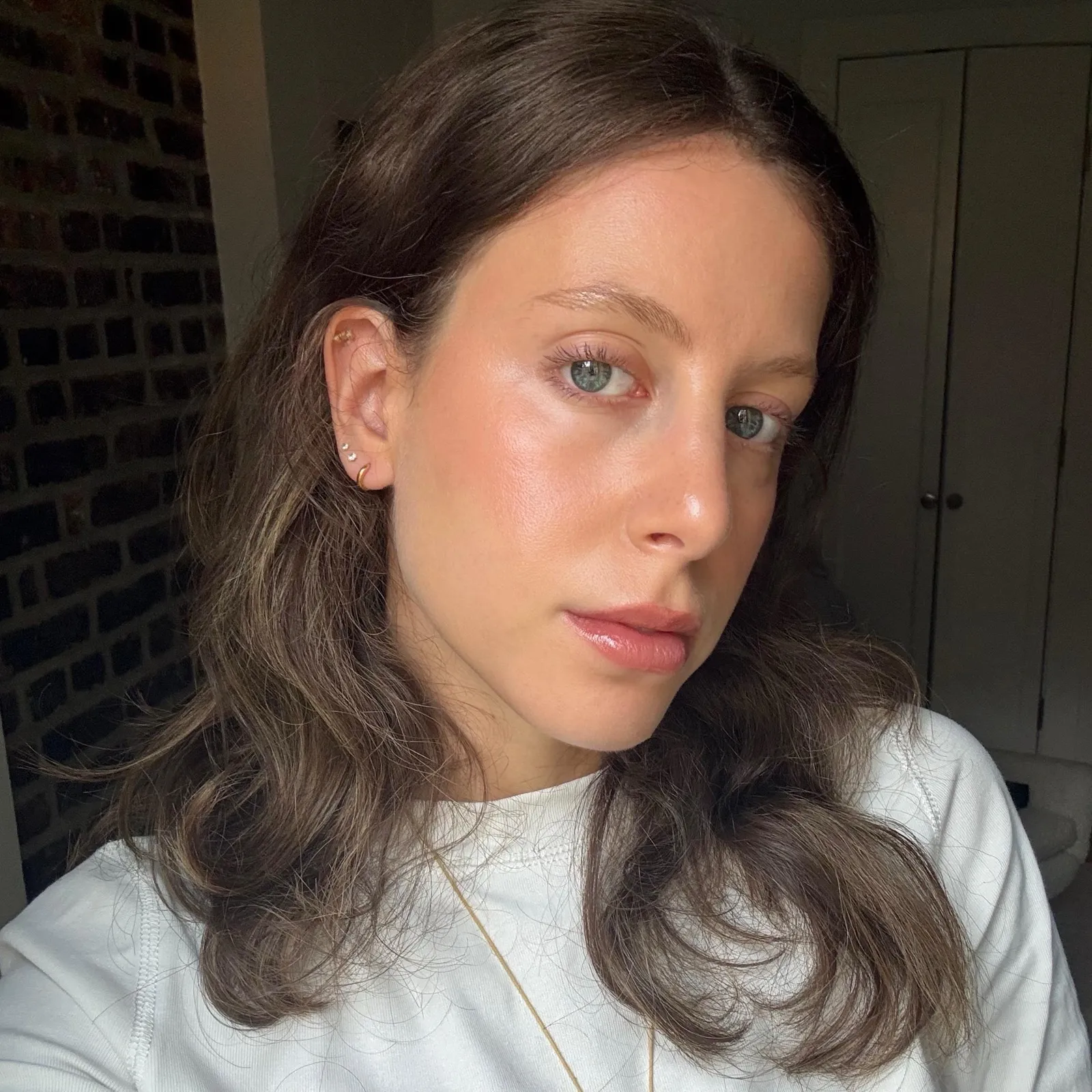 An image of WWW senior beauty editor Jamie Chevron wearing the Drunk Elephant Kamo Triple-Peptide Multi-Use Serum Foundation.