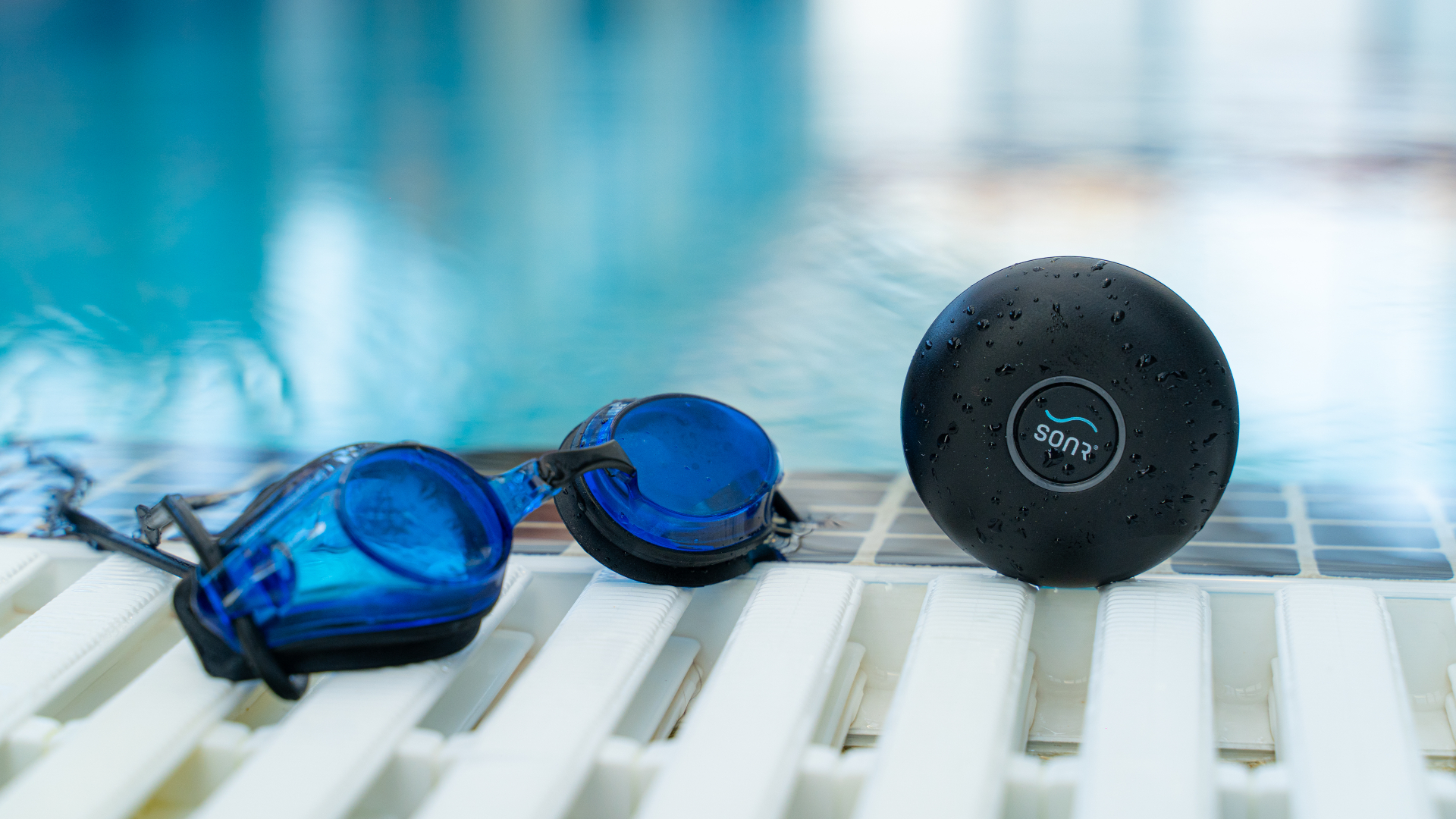 SONR Música al borde de una piscina, junto a un par de goggles