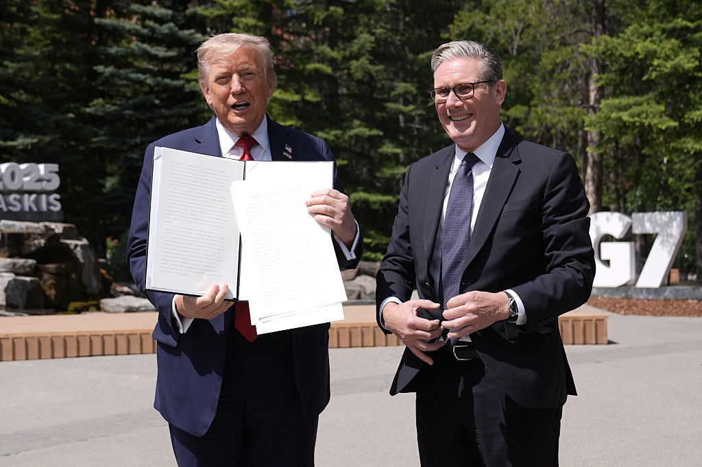 US president Donald Trump (left) holding a UK-US trade deal with prime minister Keir Starmer while speaking to the media at the G7 Leaders' Summit on 16 June 2025 in Kananaskis, Canada.